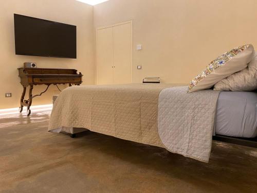 una camera da letto con un letto, un pianoforte e una TV di Suite di Bianca a Foligno