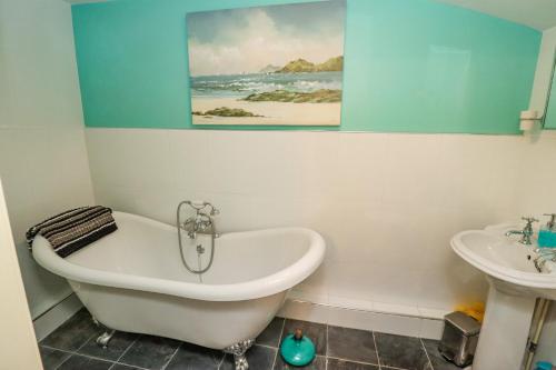 a bathroom with a bath tub and a sink at Cholmley Cottage in Whitby