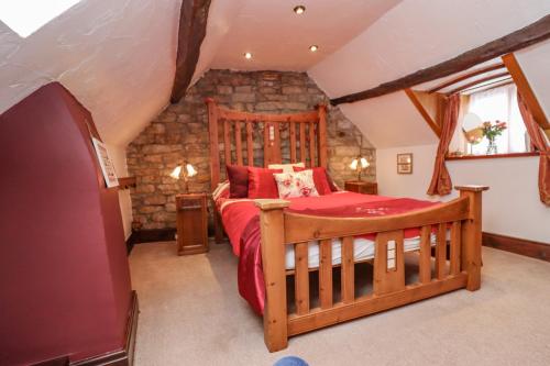 1 dormitorio con cama de madera en el ático en Cholmley Cottage, en Whitby