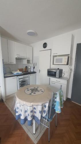 une petite cuisine avec une table et des chaises. dans l'établissement Vue sur les Dourbes Studio 44 Thermes, à Digne-Les-Bains