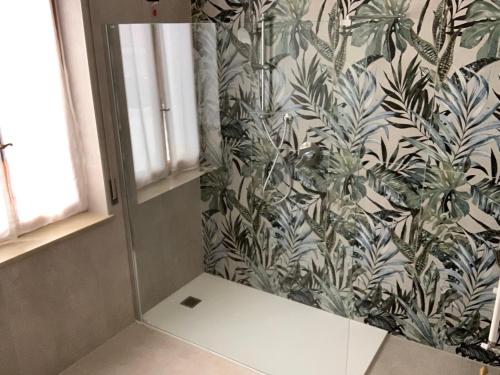 a mirror in a bathroom with a tropical wallpaper at Spagna B&B in Verona