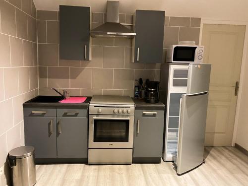 a kitchen with stainless steel appliances and a microwave at Nordic Nest in Givet