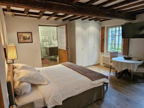 een slaapkamer met een bed en een tafel in een kamer bij Eyckenmolen B&B in Lierde