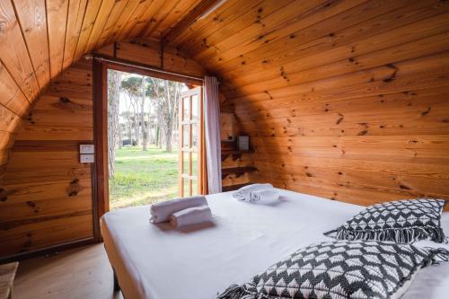 a bedroom with a bed in a wooden cabin at ISOLA VERDE Camping Village in Nettuno