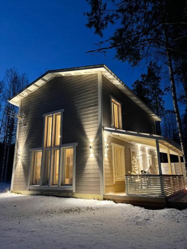 uma casa com as luzes acesas na neve em Luxurious Villa Snow with Jacuzzi em Rovaniemi