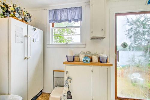 a small kitchen with a refrigerator and a window at Hartford Cottage with Dock and Private BCH on Bear Pond in Hartford