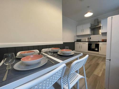 a kitchen with a table with bowls and plates on it at Strathisla Garden Apartment, Oban in Oban