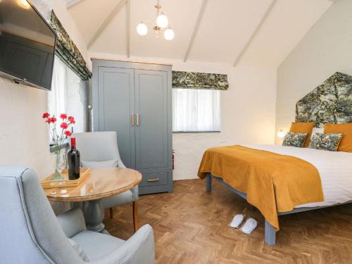 a bedroom with a bed and a desk and a table at Ees Wyke Studio in Near Sawrey
