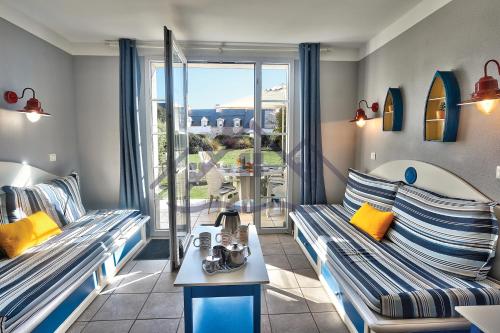 un salon avec deux canapés et une table dans l'établissement LocaLise - Maison E2 au Guilvinec - A 20m de la mer avec jardin et piscine - Tout à pied, plage, port, centre commerces, marché - Wifi inclus - Vue mer de la chambre - Animaux bienvenus - Linge de lit inclus, au Guilvinec