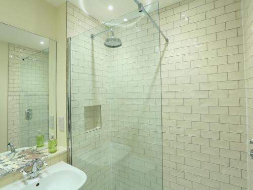 Un baño con lavabo y ducha de cristal. en 2 York House, en Dartmouth