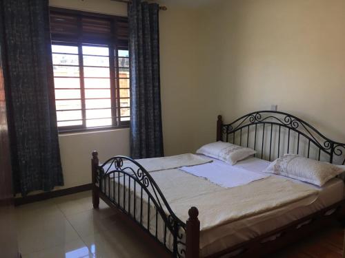 ein Schlafzimmer mit einem Bett und einem großen Fenster in der Unterkunft JM Apartment in Kigali