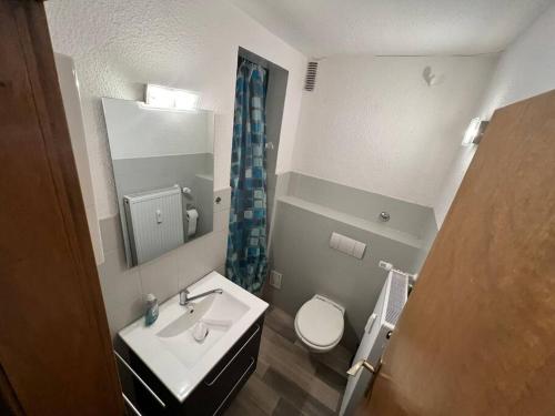ein Badezimmer mit einem Waschbecken, einem WC und einem Spiegel in der Unterkunft Zentrum MG Zimmer auf Zeit in Mönchengladbach