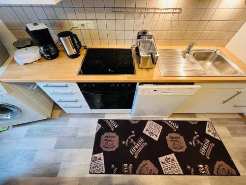 eine Küche mit einem Waschbecken und einem Küchenteppich auf dem Boden in der Unterkunft Zentrum MG Zimmer auf Zeit in Mönchengladbach