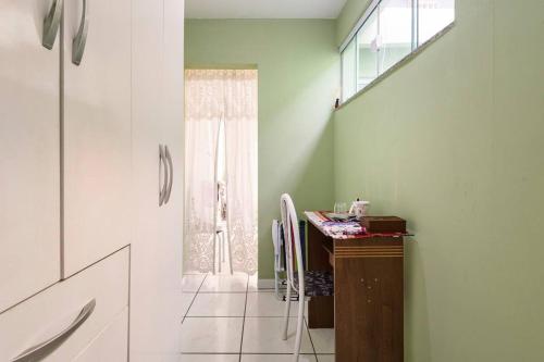 a bathroom with a desk and a window at Quarto com banheiro para solteiros no Rio de Janeiro in Rio de Janeiro