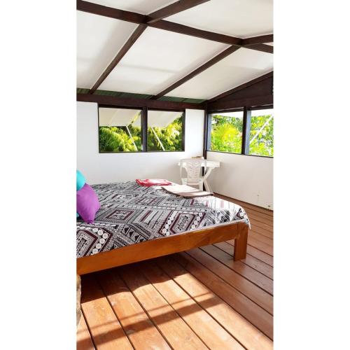 a bedroom with a bed and windows at Villa Iris in Pihaena