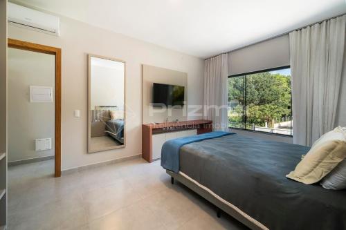 1 dormitorio con cama y ventana grande en Lindo duplex geminado na Praia de Mariscal. en Bombinhas