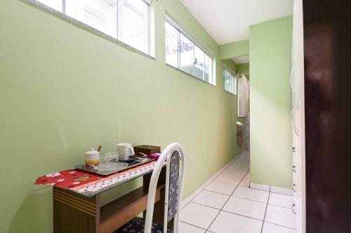 uma cozinha com um balcão e uma mesa num quarto em Quarto com banheiro para solteiros no Rio de Janeiro no Rio de Janeiro