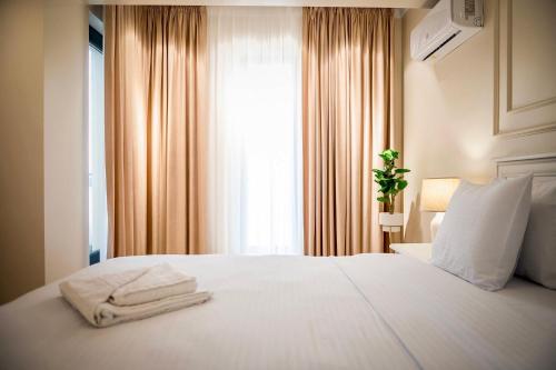 una camera da letto con un letto bianco e asciugamani di Apartament Zafi Lakeview a Constanţa