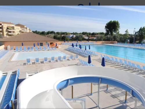 a view of the pool at a resort with chairs and a swimming pool at Chez Laure , Odalys l Elysée in Le Grau-du-Roi