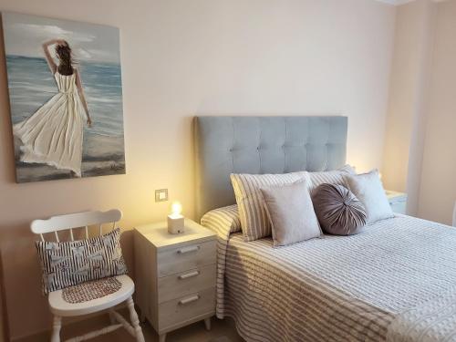 um quarto com uma cama, uma cadeira e um quadro em Ribeles Luxury Flat em Arenas de Cabrales