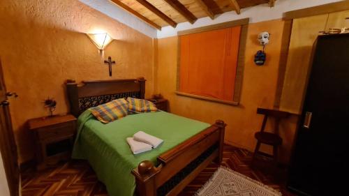 Un dormitorio con una cama verde con una cruz. en Apartamento Acogedor en el Retiro, en El Retiro