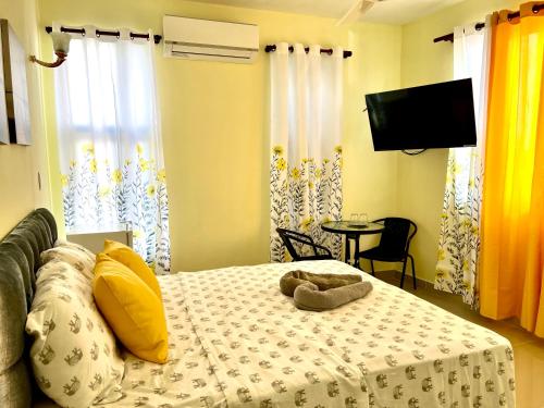 un dormitorio con una cama con un animal de peluche en Hotel María Bonita Higüey, Apartments en Higuey