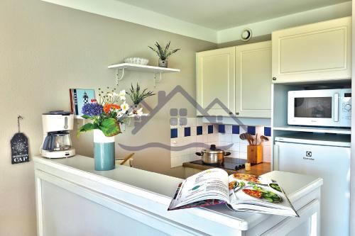 - un comptoir de cuisine avec un livre ouvert dans l'établissement LocaLise au Guilvinec - A15 - Vue sur la mer la piscine et le jardin - Tout à pied, plages, port, centre, commerces, marché - Wifi inclus - Animaux bienvenus - Linge de lit inclus, au Guilvinec