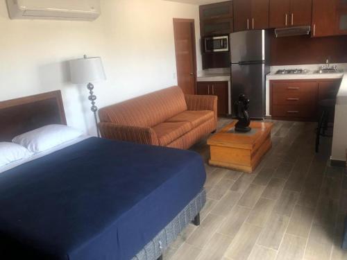 1 dormitorio con cama, sofá y cocina en Posada 53 en Mazatlán