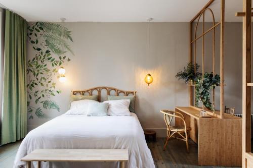 a bedroom with a large bed and a desk at CLOS REMY Maison d'hôtes in Précy-sur-Oise