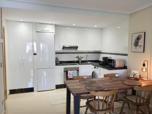 a kitchen with a wooden table and chairs in it at Ribeles Luxury Flat in Arenas de Cabrales