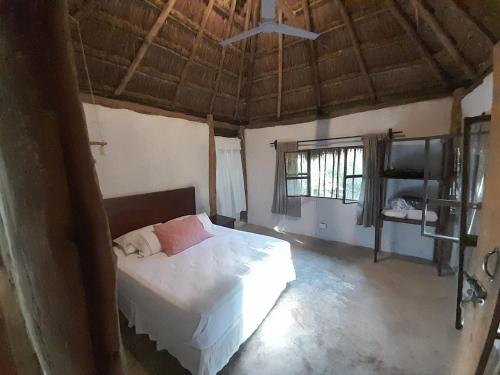 a bedroom with a bed in a room with a ceiling at Aldea Yuyu in Tulum