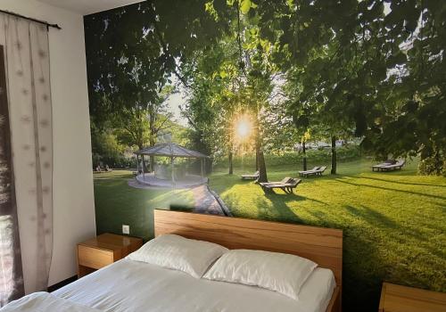 a bedroom with a large mural of a park at Jazina Hotel in Trebinje