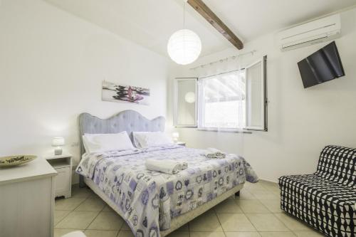 1 dormitorio con 1 cama y 1 silla en Nonno Aldo’s House en Scala