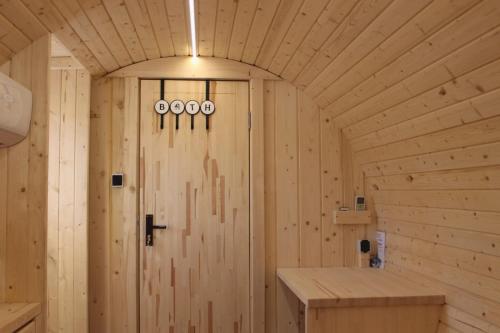 Habitación de madera con puerta de madera. en Apple Tree Lodge en Lodè