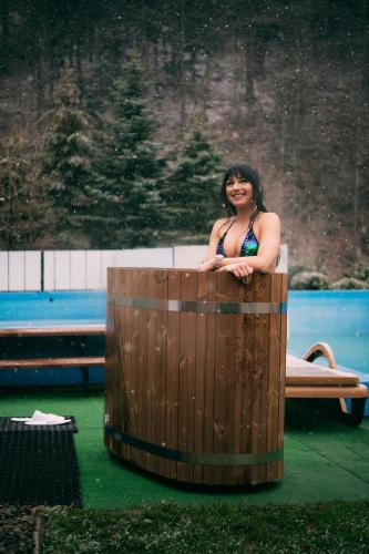 a woman is sitting in a wooden tub at Hotel Kotarz Spa&Wellness in Brenna