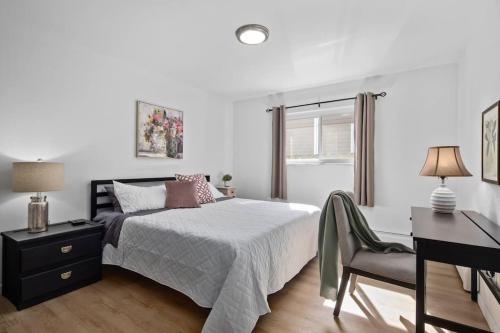 Habitación blanca con cama y escritorio en Bright & Spacious 2 Bedroom, en Mount Clemens