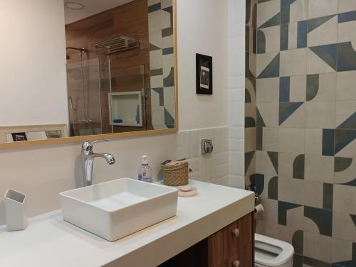 a bathroom with a sink and a mirror and a toilet at Apartamento Praia Leme Star in Rio de Janeiro