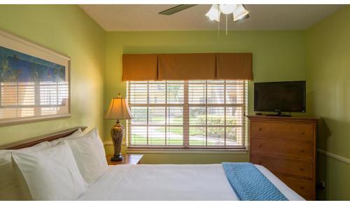 a bedroom with a bed and a flat screen tv at Gulfstream Manor in Delray Beach