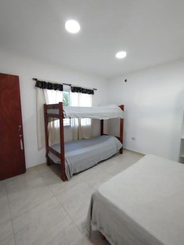 a bedroom with two beds and a window at El Temple in San Clemente del Tuyú