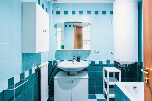 a blue bathroom with a sink and a toilet at Pavillon d'Angleterre au cœur de la ville in Menton