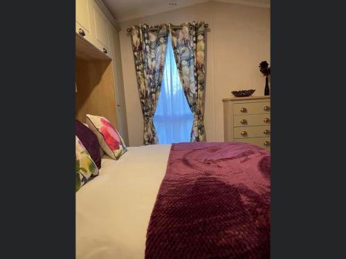 a bedroom with a bed and a window at Forest Lake Lodge in Landford