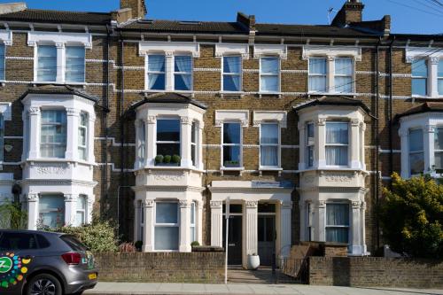 ロンドンにあるFabulous 3 bed NW London apartment with private gardenの車が停まった家
