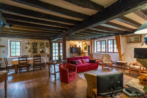 un salon avec un canapé rouge et une table dans l'établissement Altzugarria, ancienne ferme Basque, authentique et familiale à Sare, à Sare