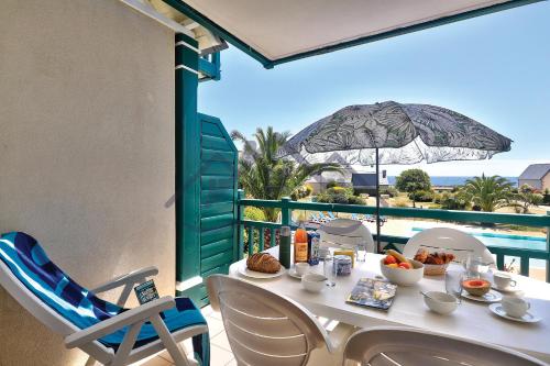 une table et des chaises sur un balcon avec vue sur l'océan dans l'établissement LocaLise au Guilvinec - A16 - Vue sur la mer, la piscine et le jardin - Tout à pied, plages, port, centre, commerces, marché - Wifi inclus - Animaux bienvenus - Linge de lit inclus, au Guilvinec