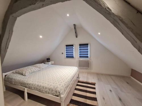um quarto branco com uma cama num sótão em L'atelier Abbevillois by H2C em Abbeville