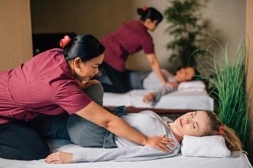 a woman laying on a bed while another woman is helping a patient at Hotel Kotarz Spa&Wellness in Brenna