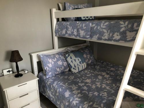 ein Schlafzimmer mit einem Etagenbett und einem Sofa in der Unterkunft The Starfish Cottage in Scottburgh