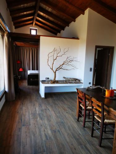 a living room with a table and a tree on the wall at Casa Romantica in Petriaí