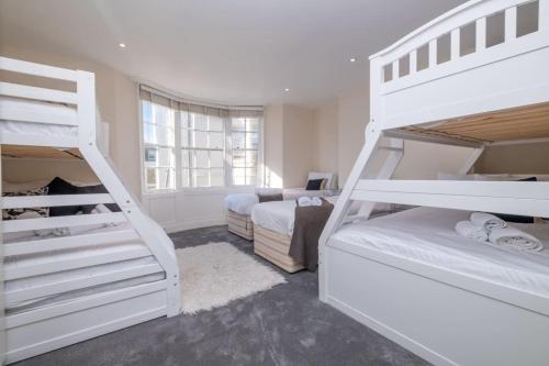 a bedroom with two bunk beds and a room with two beds at Large Central Brighton Townhouse Close to Pier in Brighton & Hove