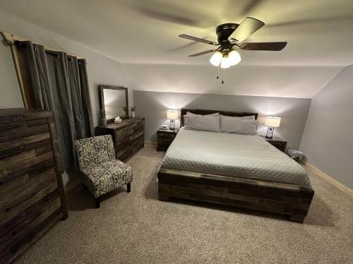 a bedroom with a bed and a ceiling fan and a chair at Osceola #13 Mine House 